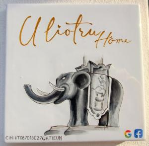 Un dibujo de un elefante sosteniendo un libro. en U Liotru home, en Catania