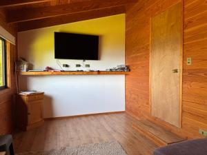 ein Wohnzimmer mit einem Flachbildfernseher an der Wand in der Unterkunft Casa Orilla Lago Villarrica in Villarrica + 25 Fotos