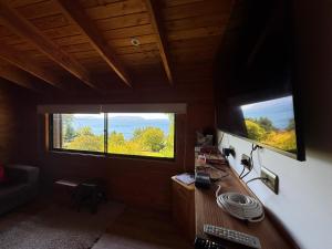 Zimmer mit 2 Fenstern und einem Schreibtisch mit einem Computer in der Unterkunft Casa Orilla Lago Villarrica in Villarrica