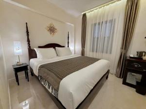 a bedroom with a large bed and a window at Onson De Boutique Hotel in Luang Prabang