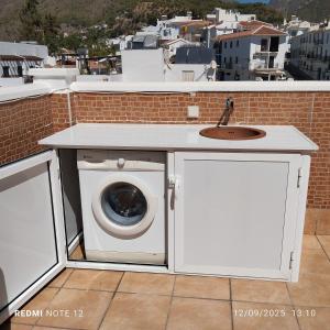a washing machine and a sink on a balcony at El ático de la Cañada in Frigiliana +18 photos