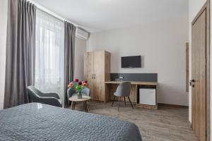 a hotel room with a bed and a desk and chairs at Seven Hills Hotel in Stoyanka