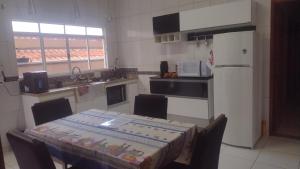 a small kitchen with a table and a refrigerator at Casa Aconchegante in Espirito Santo Do Pinhal