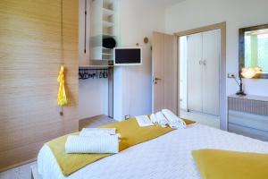 a bedroom with a large bed with towels on it at Panorama e Relax Lago Maggiore - piscina, tennis in Germignaga