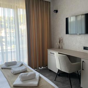 a hotel room with a desk and a television at Zlate Home in Zlatograd
