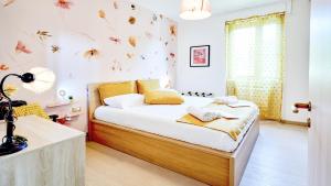 a bedroom with a bed and a window with butterflies on the wall at Panorama e Relax Lago Maggiore - piscina, tennis in Germignaga