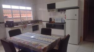 a kitchen with a table with a table cloth on it at Casa Aconchegante in Espirito Santo Do Pinhal
