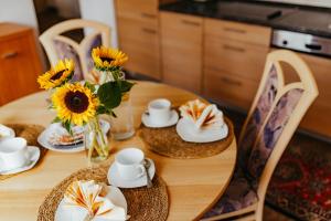 a dining room table with sunflowers on it at Ferienwohnungen Krampert in Bad Kissingen +4 photos