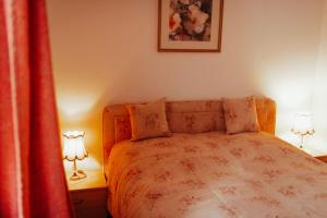 a bedroom with a bed with two lamps and a curtain at Ferienwohnungen Krampert in Bad Kissingen