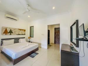 a bedroom with a large bed and a tv at Sunrise Palace Negombo in Negombo