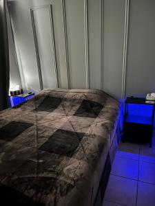 a bed in a room with blue lights at Le Numéro 1 in Val-Brillant +10 photos