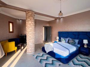 a bedroom with a blue bed and a stone pillar at Room 1 villa sunset Bouzerktoun in Essaouira +53 photos