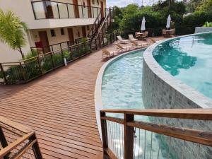 a wooden deck next to a swimming pool at Brisa do Mar loft in Morro de São Paulo