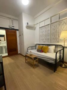 a bedroom with a bed with yellow pillows and a table at The Open House Cafe and Hostel in Bangkok