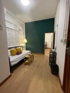 a living room with a bed and a green wall at The Open House Cafe and Hostel in Bangkok +21 photos