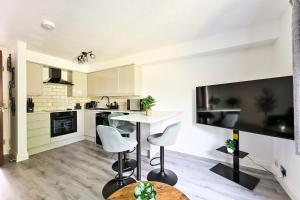 a kitchen with a table and two stools at 1 Bed flat in London with Free Parking in Colindale