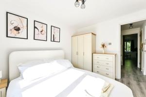 a white bedroom with a bed and a dresser at 1 Bed flat in London with Free Parking in Colindale