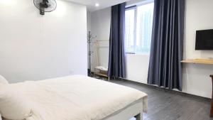 a bedroom with a white bed and a window at Khách Sạn Diamond Hotel Văn Giang Hưng Yên in Cửu Cảo