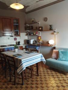a kitchen with a table with chairs and a couch at Ca' d'la nona casa con giardino in Agliano Terme +26 photos