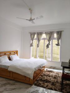 a bedroom with a bed and a large window at Gonpapa Homestay in Dirang Dzong