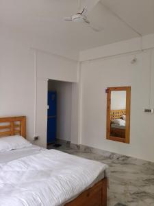 a bedroom with a bed and a mirror on the wall at Gonpapa Homestay in Dirang Dzong