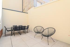 a room with black chairs and a table and a wall at Maisonnette Stella Plage Terrasse WIFI in Cucq