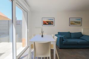 a living room with a couch and a table at Maisonnette Stella Plage Terrasse WIFI in Cucq