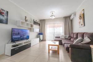 a living room with a couch and a flat screen tv at Fabulous two bedroom apartment near las Vistas Beach in Los Cristianos in Arona