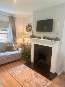 a living room with a fireplace with a tv above it at No.14 in Bunratty