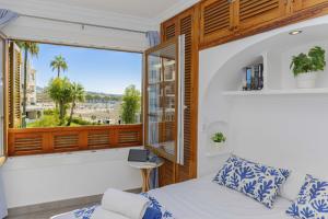 a bedroom with a bed and a large window at Apartamento Carabela 51 in Port d'Alcudia