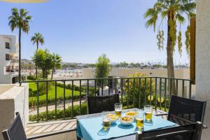a table with food on a balcony with a view of the beach at Apartamento Carabela 51 in Port d'Alcudia