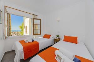 two beds in a room with a window at Apartamento Carabela 51 in Port d'Alcudia +29 photos