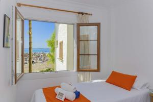 een slaapkamer met een raam met uitzicht op het strand bij Apartamento Carabela 51 in Port d'Alcudia +55 foto's