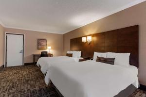 two beds in a hotel room with white sheets at Best Western Ville-Marie Montreal Hotel & Suites in Montreal +51 photos