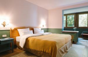 a bedroom with a large bed with a yellow blanket at HENRI Hotel Garmisch-Partenkirchen in Garmisch-Partenkirchen