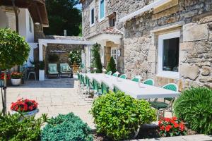 a patio with a white table and green chairs at La casa de los Barbazanes in Brion