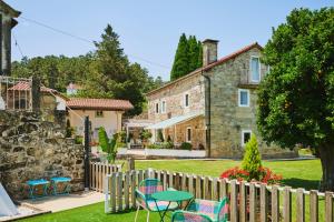 奥比昂La casa de los Barbazanes的房屋前设有带桌椅的花园