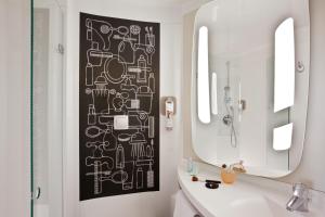 a bathroom with a black and white pattern on the wall at ibis Paris Saint-Denis Stade Sud in Saint-Denis