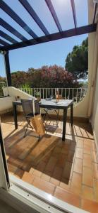 勒格罗-迪鲁瓦Terrasse 4 quai du port de plaisance的露台上有一张桌子和几把椅子