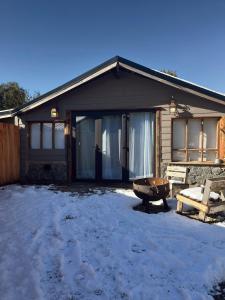een huis in de sneeuw met een bank ervoor bij Nido 12 in Bariloche