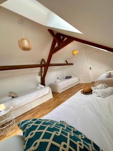 a large room with two beds and a ceiling at La Casa César Maison 10 couchages in Bracquemont