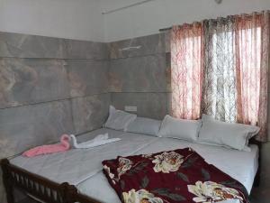 a bed in a room with two windows at winter green valley in Vagamon