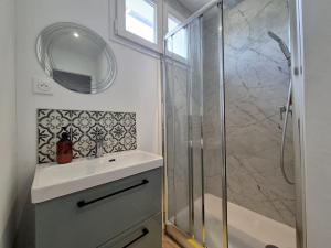 a bathroom with a sink and a glass shower at Villahermosa, un oasis artistique in Tinqueux +11 photos