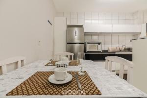 - une cuisine avec une table et des assiettes dans l'établissement Apartamentos a 400 m da Praia em BC - CEV, à Balneário Camboriú