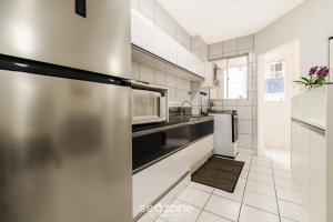 une cuisine avec un réfrigérateur et un micro-ondes dans l'établissement Apartamentos a 400 m da Praia em BC - CEV, à Balneário Camboriú 48 autres photos
