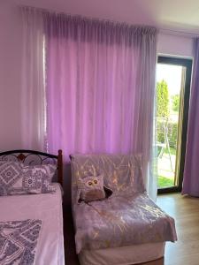 a bedroom with purple curtains and a bed and a window at Boulevard Sea Residenz 250 meter zum Sandstrand in Sunny Beach