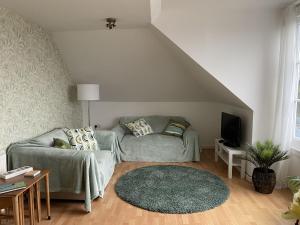 a living room with a couch and a tv at Skibo Vista Dunfermline in Dunfermline