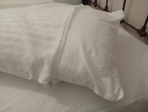 a bed with a white blanket on top of it at Gascona con Deli in Oviedo +11 photos