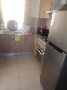 a kitchen with a stainless steel refrigerator and a stove at S2 JDC jardin de carthage in Tunis