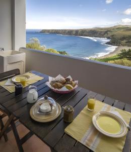 een tafel met eten en uitzicht op de oceaan bij Beach House - Mountain And Ocean in Ribeira Seca do Porto